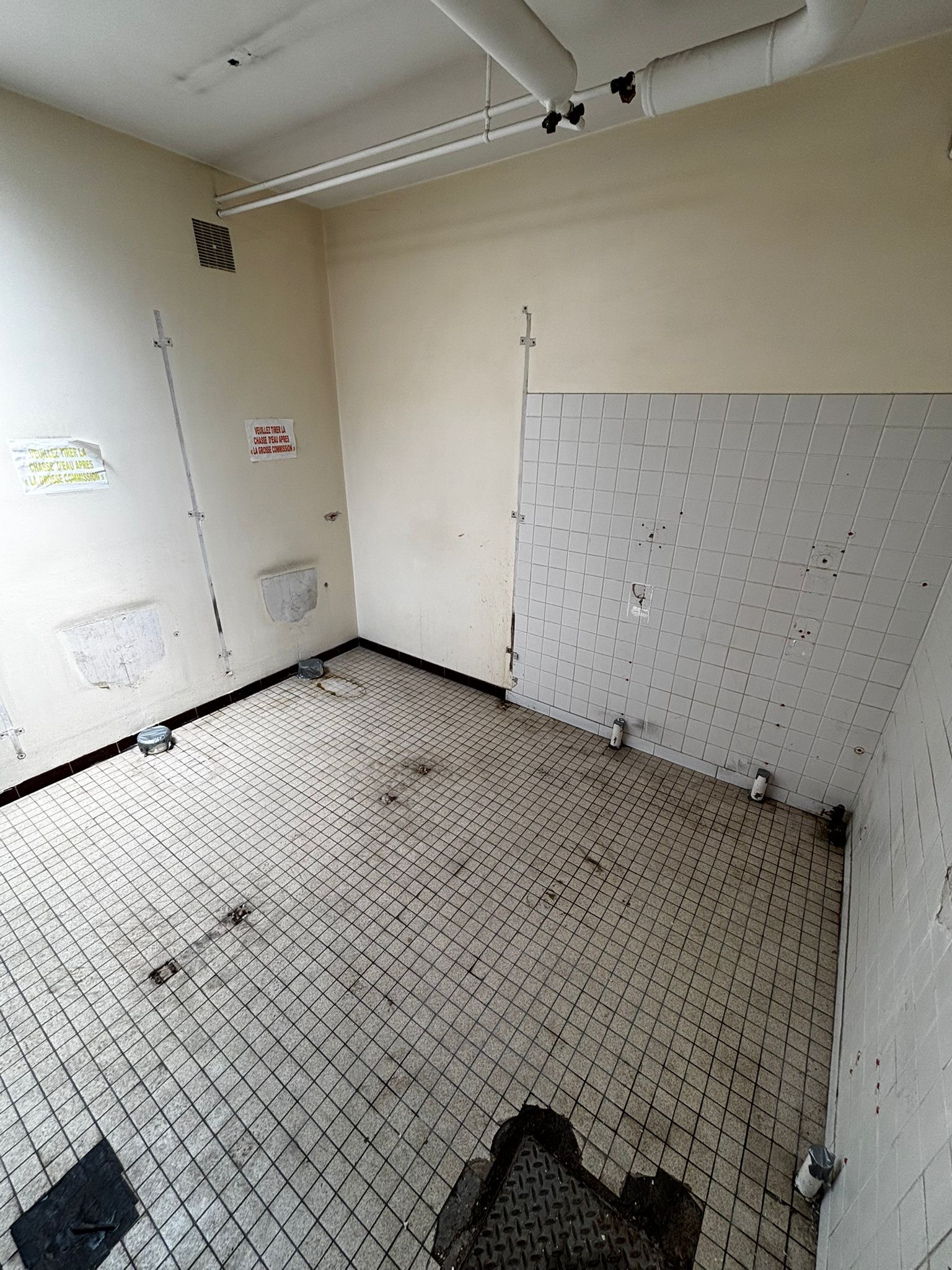 Zone carrelee apres retrait des urinoirs et accessoires